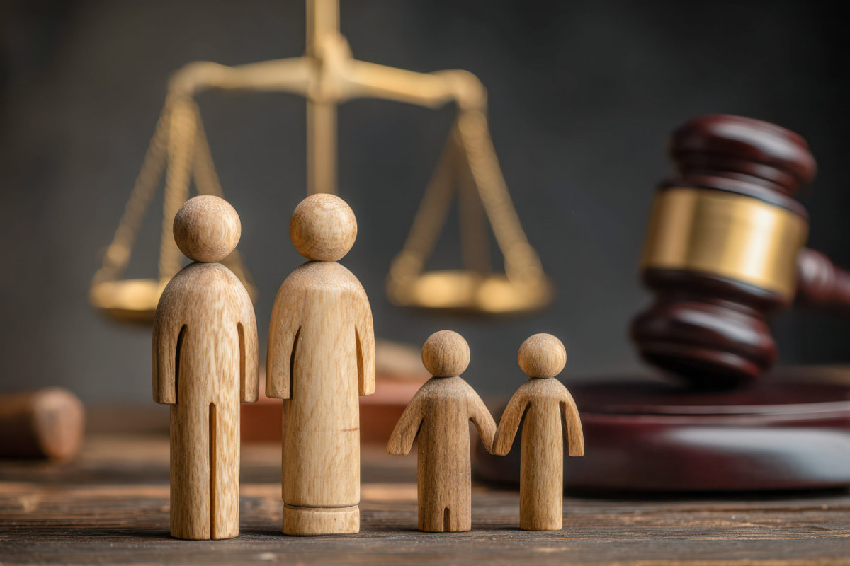 Woden figurines, representing a family, alongside symbols of justice